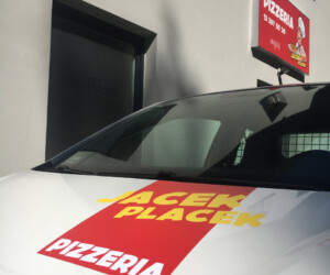 Pizzeria Jacek Placek Auto firmowe Pizzeria Jacek Placek, w tle kaseton reklamowy